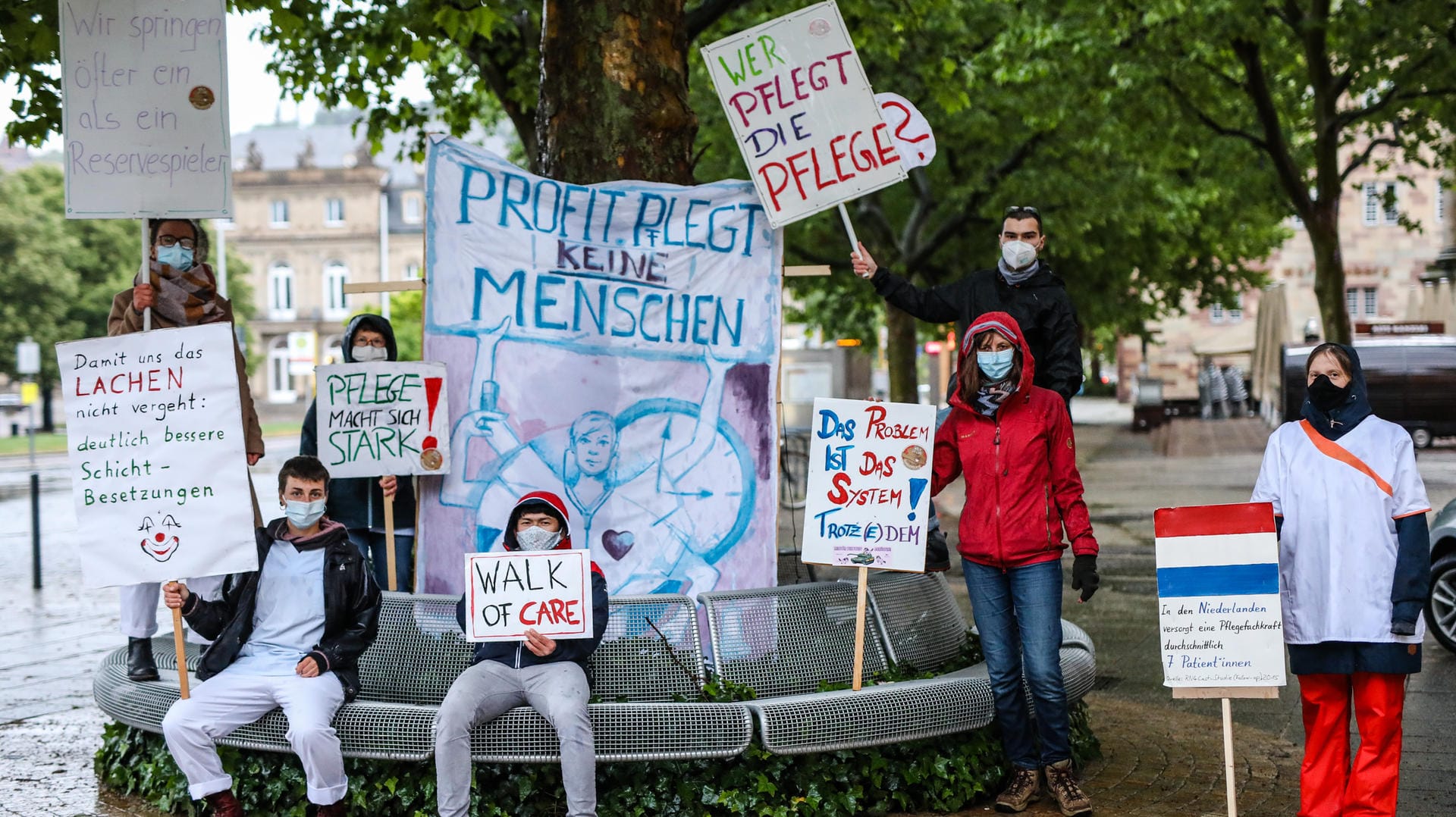 Pflegekräfte nehmen mit Schildern wie "Profit pflegt keine Menschen" auf dem Schlossplatz an der 24-Stunden Mahnwache "Walk of Care" teil: So wollen sie auf Misstände in der Pflege hinweisen.