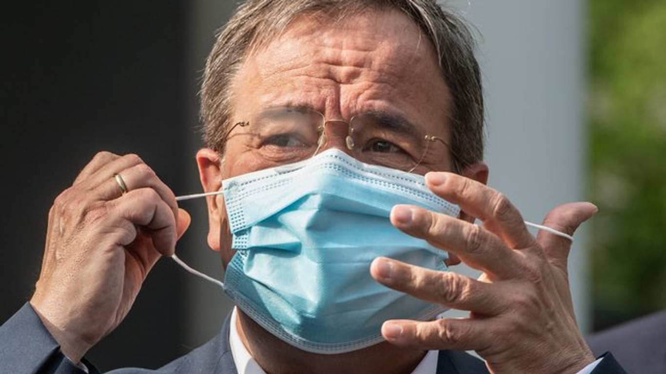 NRW-Ministerpräsident Armin Laschet (CDU) setzt eine Maske auf