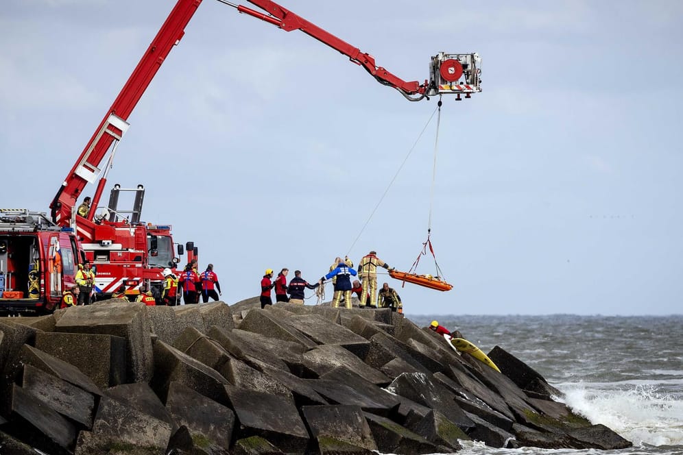 Rettungskräfte bergen eine Leiche, die sie bei der erneuten Suche nach den vermissten Wassersportlern im Noordelijk Havenhoofd gefunden haben.