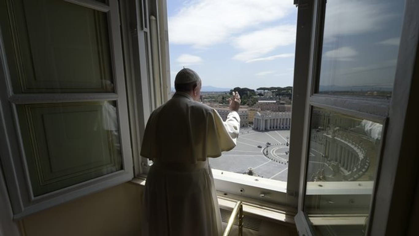 Papst Franziskus erteilt aus dem Fenster seinen Segen mit Blick auf den Petersplatz, der aufgrund der Anti-Corona-Maßnahmen menschenleer ist.