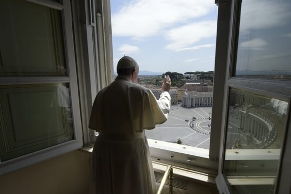 Papst Franziskus erteilt aus dem Fenster seinen Segen mit Blick auf den Petersplatz, der aufgrund der Anti-Corona-Maßnahmen menschenleer ist.