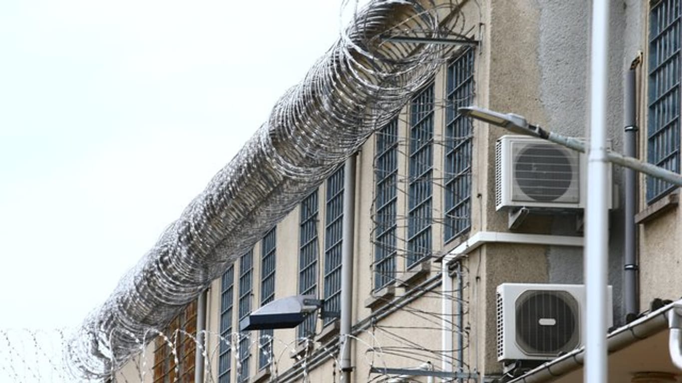 Stacheldraht und vergitterte Fenster umzeunen ein Gefängnis