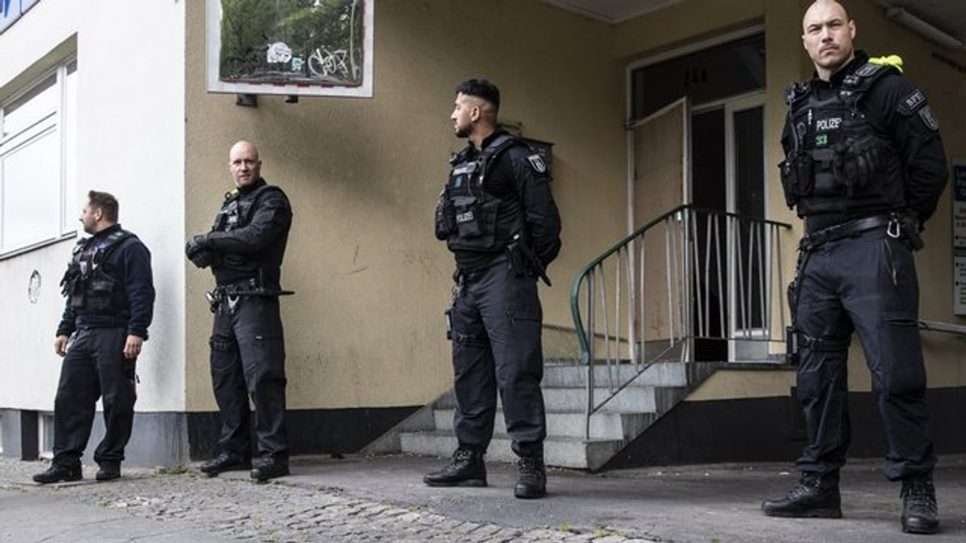 Polizeibeamte stehen im Rahmen einer Razzia auf der Mecklenburgischen Straße in Berlin.