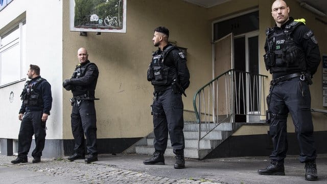 Polizeibeamte stehen im Rahmen einer Razzia auf der Mecklenburgischen Straße in Berlin.