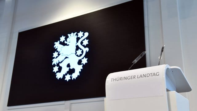 "Thüringer Landtag" steht auf dem Rednerpult vor dem Landeswappen