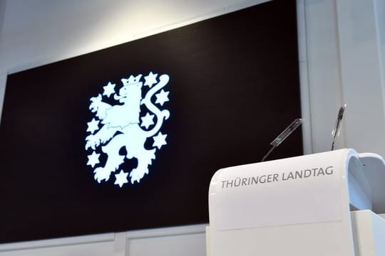 "Thüringer Landtag" steht auf dem Rednerpult vor dem Landeswappen