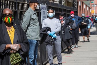 Menschen mit Gesichtsmasken: Vor einer Kirche im New Yorker Stadtteil Harlem hat sich eine Schlange gebildet – hier können sich einkommensschwache Menschen auf Corona testen lassen.