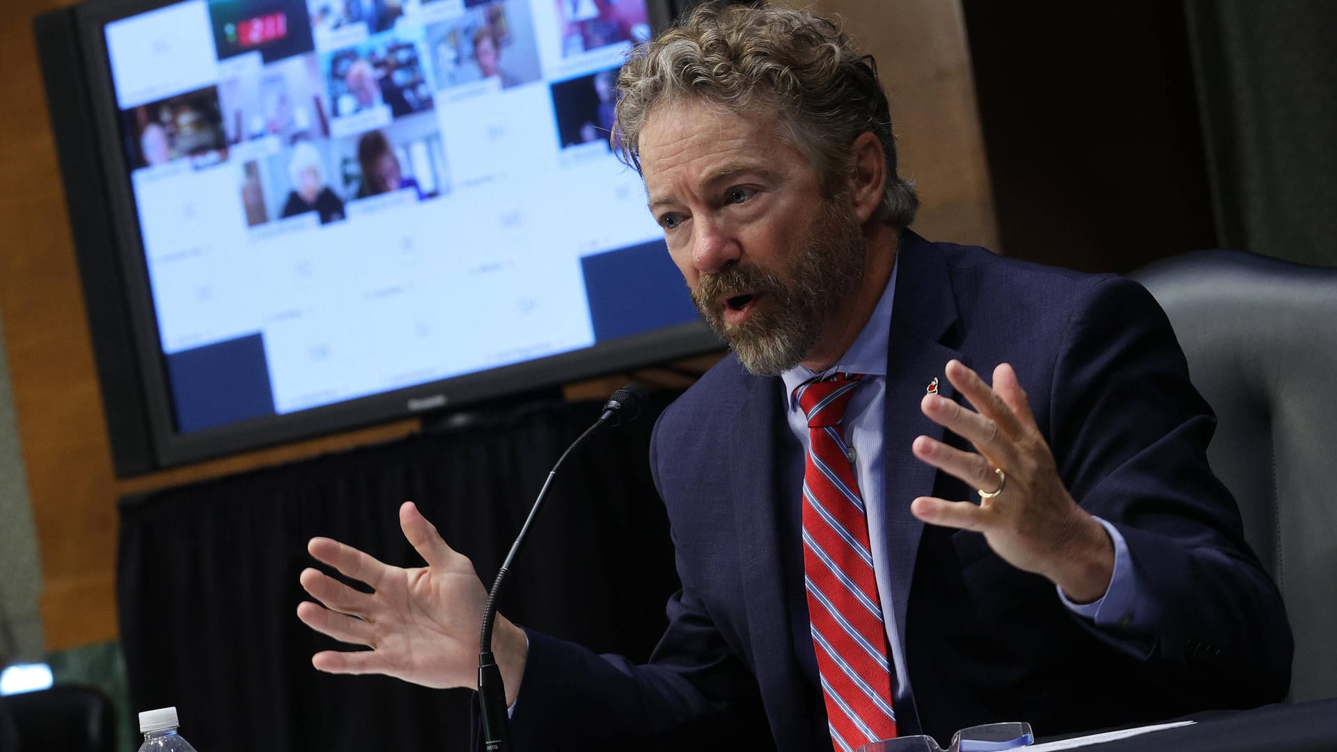 Senator Rand Paul (r.) spricht vor Ort ohne Maske, im Hintergrund der Bildschirm mit den zahlreichen Teilnehmern aus dem Homeoffice.