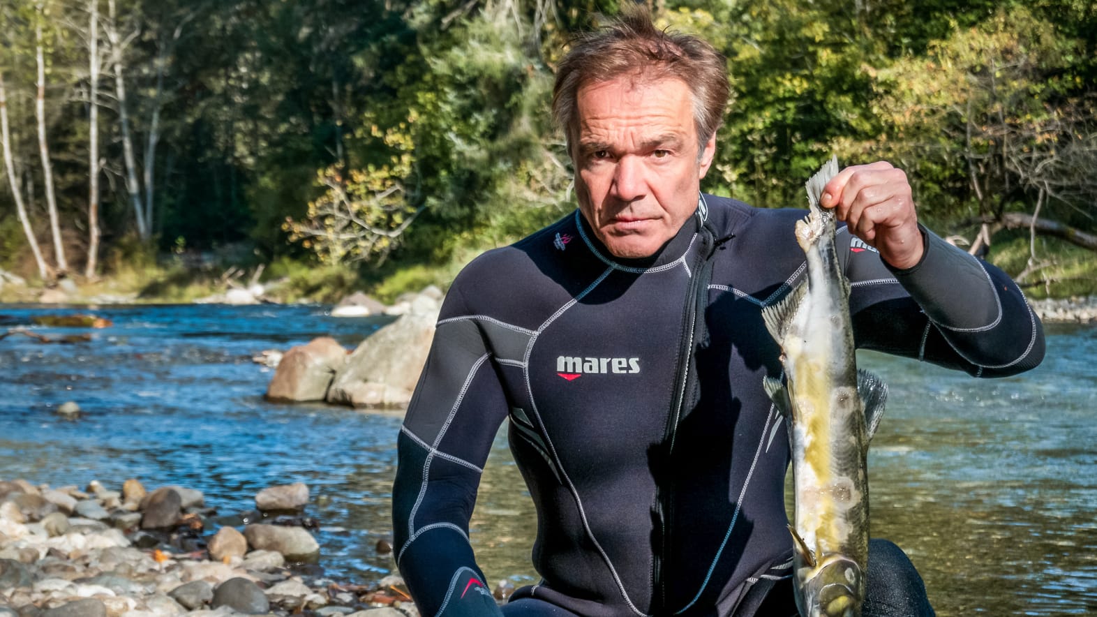 Hannes Jaenicke am Campbell River auf Vancouver Island in Kanada mit einem toten Lachs: Immer mehr Buckellachse sterben hier bevor sie ihre Laichgründe erreichen können.