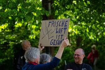 Ein Demonstrant in Flensburg hält ein Transparent mit der Aufschrift "Frische Luft ist gesund": In ganz Deutschland protestieren Menschen gegen die Corona-Maßnahmen.