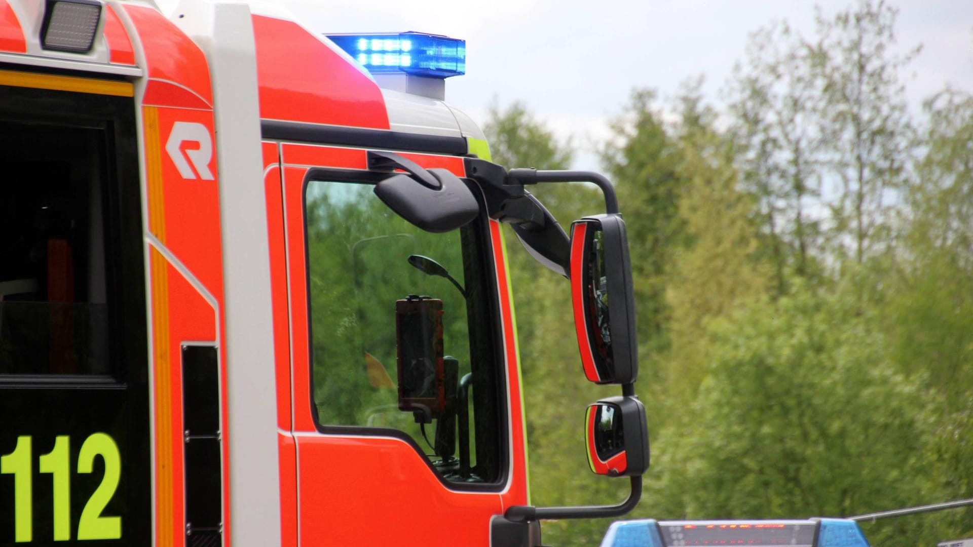 Blaulicht leuchtet auf einem Feuerwehrwagen (Symbolbild): Im Treppenhaus eines Mehrfamilienhauses stand ein Kinderwagen in Flammen.