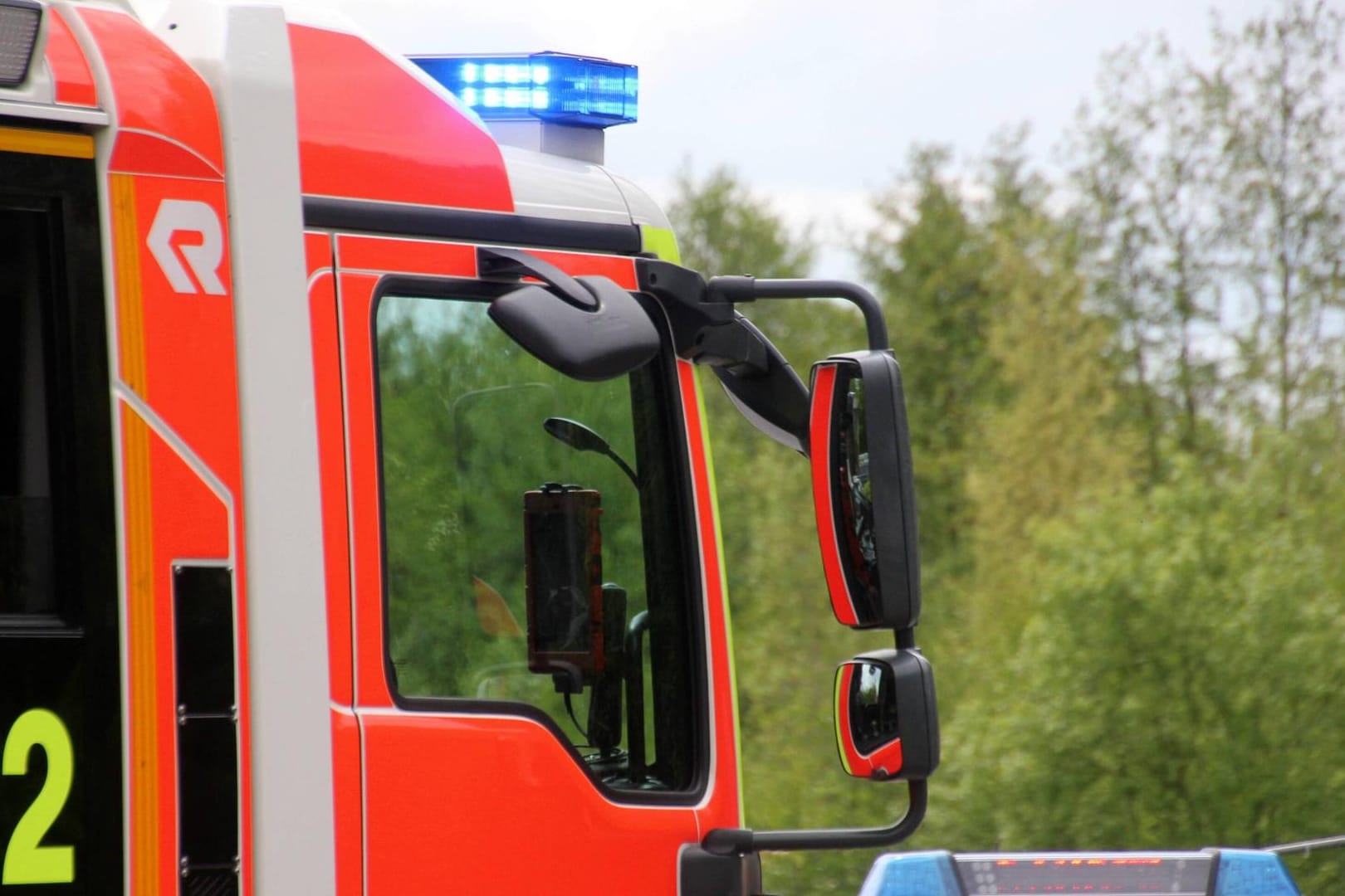 Blaulicht leuchtet auf einem Feuerwehrwagen (Symbolbild): Im Treppenhaus eines Mehrfamilienhauses stand ein Kinderwagen in Flammen.