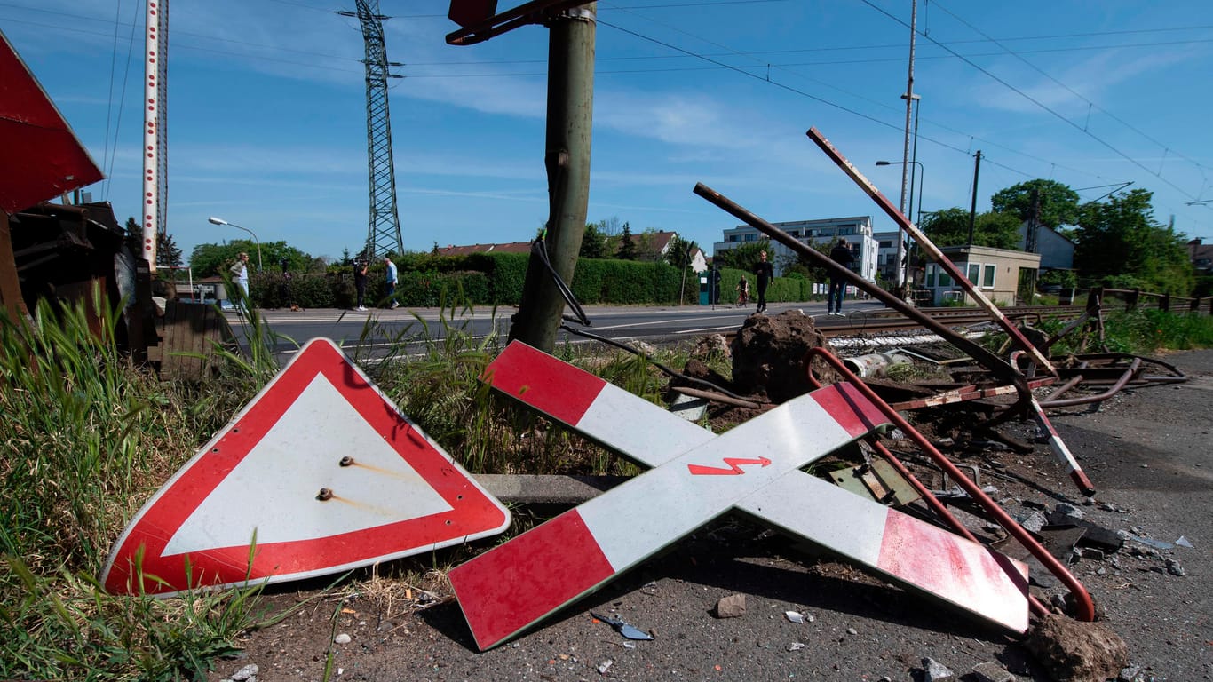 Schilder liegen am Bahnübergang in Frankfurt-Nied nach einem tödlichen Unfall auf der Straße: Nach bisherigen Ermittlungen waren die Schranken zum Zeitpunkt des Unglücks nicht geschlossen.