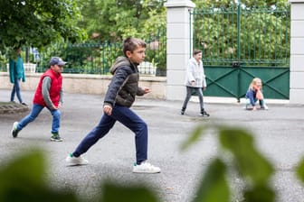Kinder spielen auf einem Schulhof (Symbolbild): Eine Lehrerin aus Frankfurt wollte dem Unterrichtsstart mit einem Eilantrag beim Gericht umgehen.