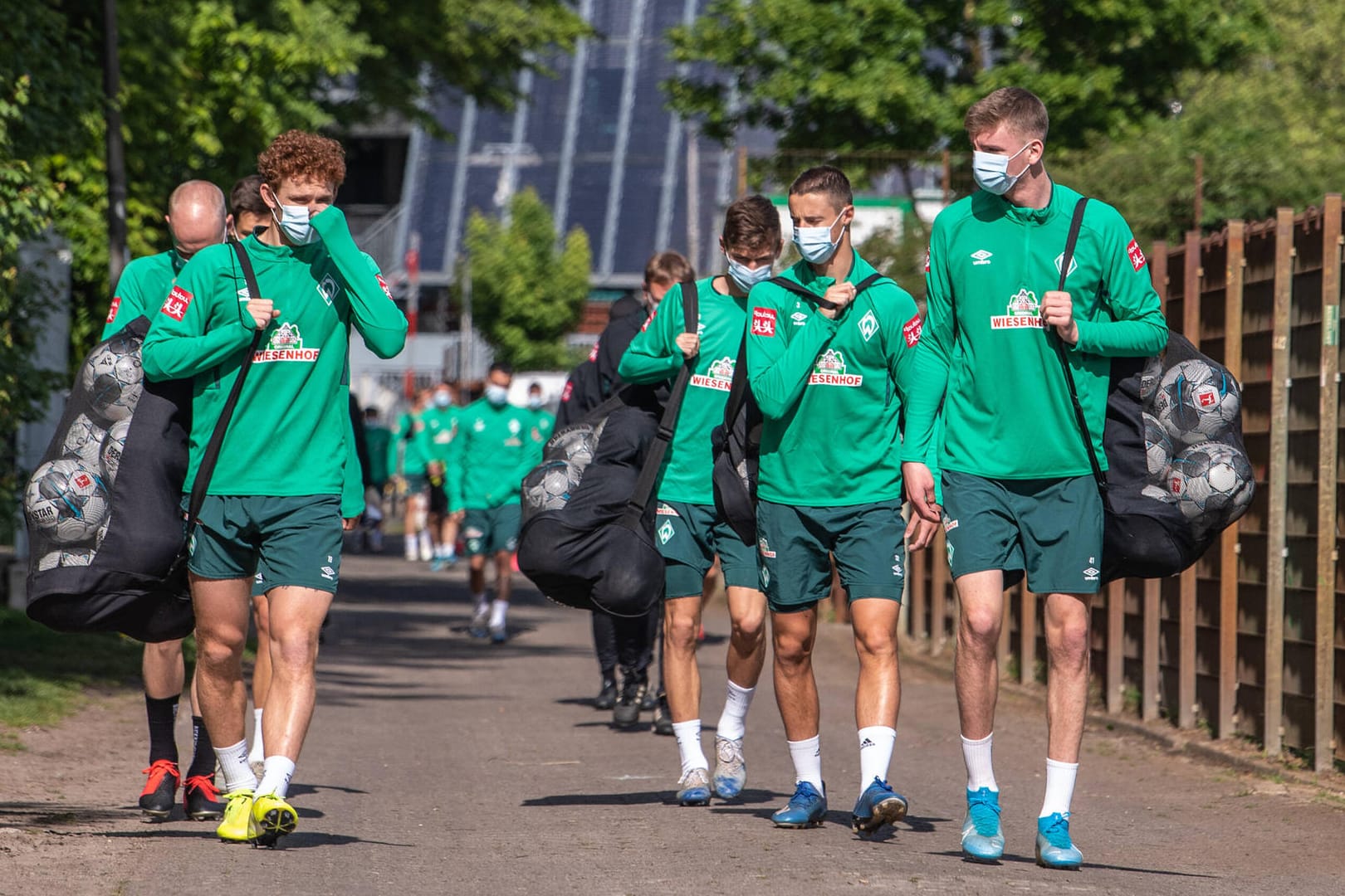 Die Bremer Profis mit Gesichtsmaske auf dem Weg zum Training. Werder steckt tief im Abstiegskampf – und muss nun noch auf einen Spieler verzichten, der in Quarantäne geschickt wurde.