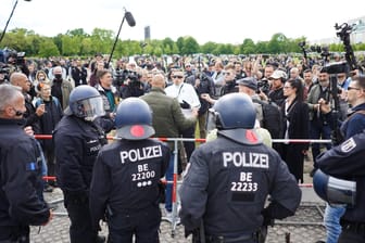 Durch eine Absperrung getrennt stehen Polizeibeamte vor dem Berliner Reichstag einer größeren Zahl von Demonstranten gegenüber: In vielen Städten in ganz Deutschland sind am Samstag erneut Tausende Menschen gegen die Corona-Maßnahmen auf die Straße gegangen.