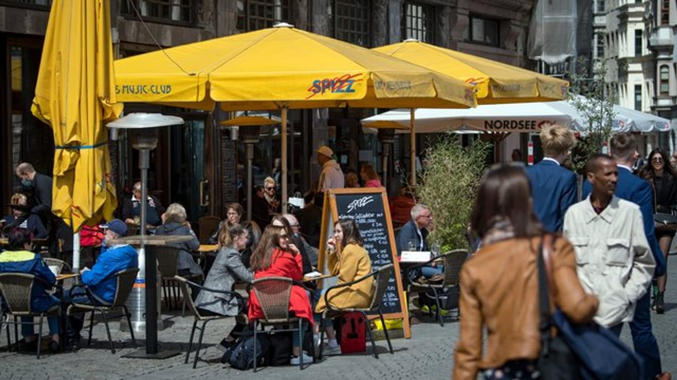 Menschen sitzen in einem Restaurant am Marktplatz