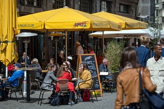 Menschen sitzen in einem Restaurant am Marktplatz