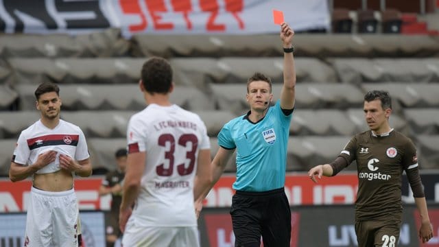 Der Schiedsrichter zeigt Nürnbergs Torwart die Rote Karte Der Schiedsrichter zeigt Nürnbergs Torwart die Rote Karte