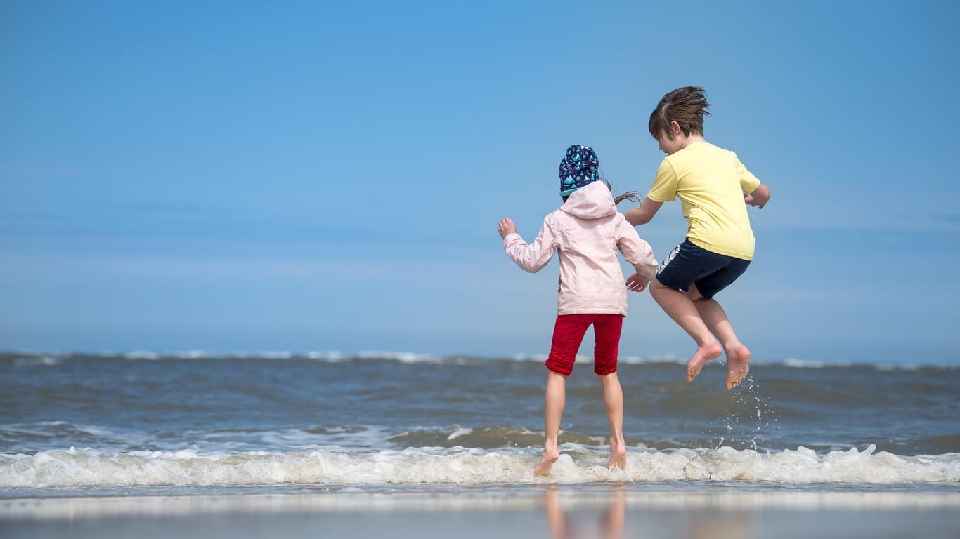 Kinder spielen am Strand: Am Spiekerooger Strand sind derzeit keine besonderen Maßnahmen wegen des Coronavirus geplant.