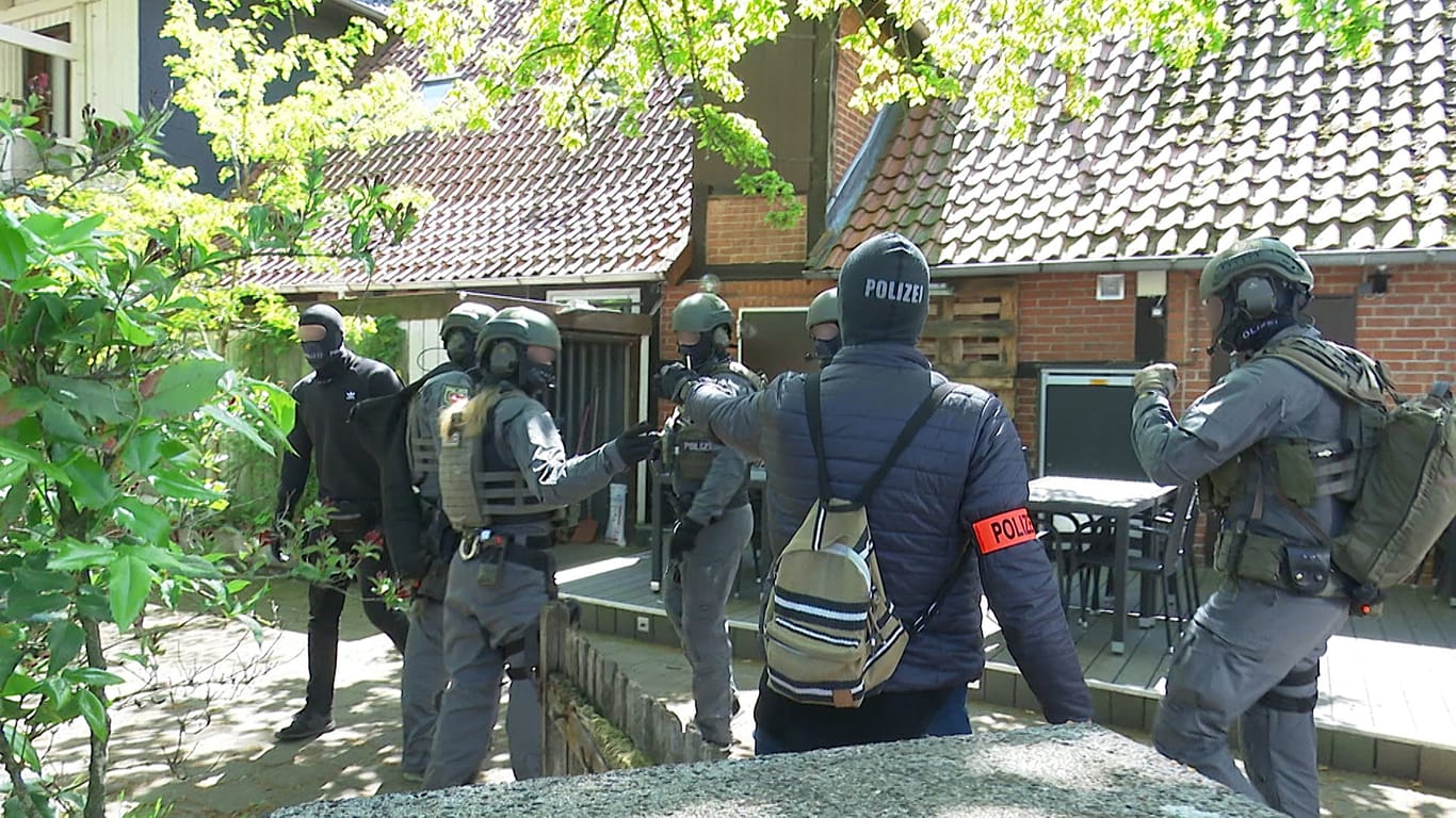 Polizisten stehen vor einem Haus in Niedersachsen: Dort haben Ermittler einen 52-jährigen Kieler, sieben Monate nach seinem vermeintlichen Ertrinken in der Ostsee, ausfindig gemacht.