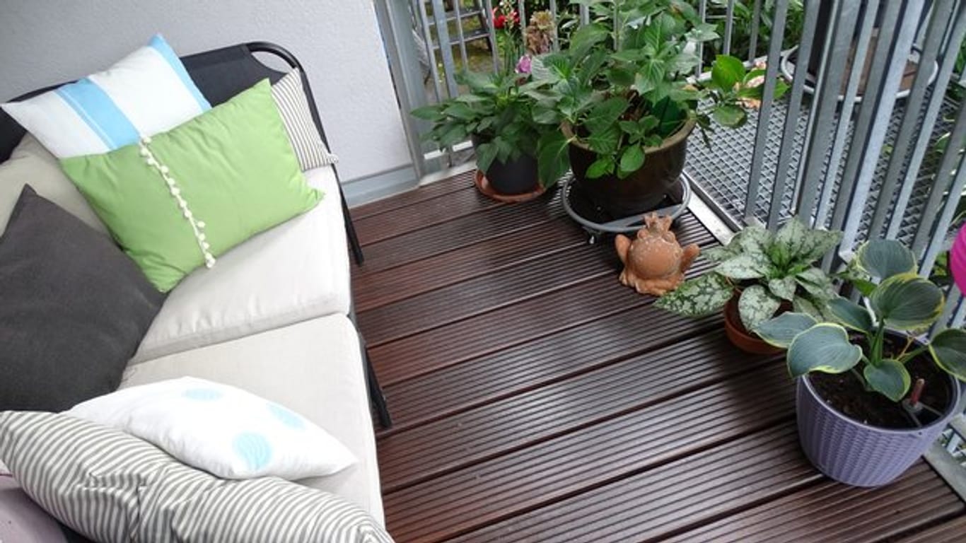 Damit Holzdielen auf einem Balkon so schön bleiben, sollten sie regelmäßig mit einem passenden Pflegeöl behandelt werden.