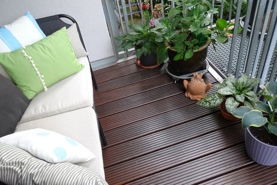 Damit Holzdielen auf einem Balkon so schön bleiben, sollten sie regelmäßig mit einem passenden Pflegeöl behandelt werden.