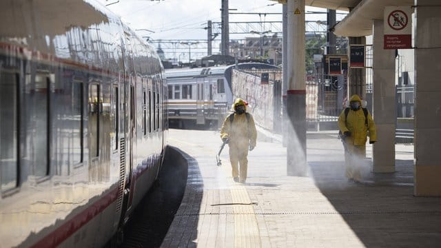 Staatliche Mitarbeiter in Schutzkleidung desinfizieren den Kiewer Bahnhof in Moskau. Staatliche Mitarbeiter in Schutzkleidung desinfizieren den Kiewer Bahnhof in Moskau.