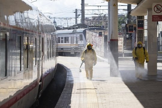 Staatliche Mitarbeiter in Schutzkleidung desinfizieren den Kiewer Bahnhof in Moskau.