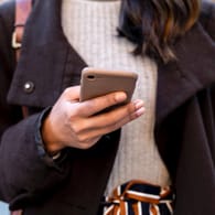 Eine Frau mit einem Smartphone in der Hand (Symbolbild): Das Galaxy A51 gilt im ersten Quartal 2020 als das meistverkaufte Android-Smartphone weltweit.