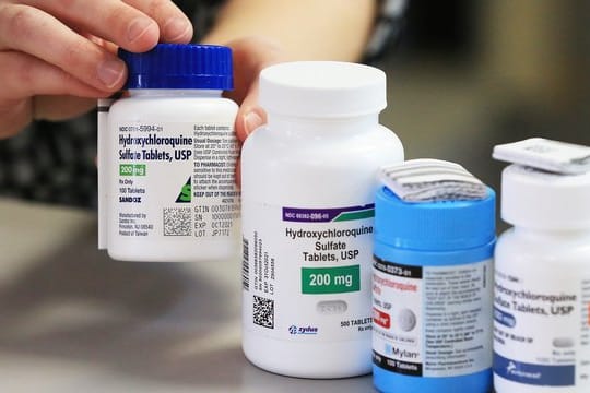 Ein Apotheker zeigt in einer Apotheke Dosen mit dem Medikament Hydroxychloroquin von verschiedenen Herstellern (Symbol).