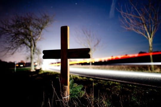 Ein Kreuz zur Erinnerung an einen Verkehrstoten am Straßenrand