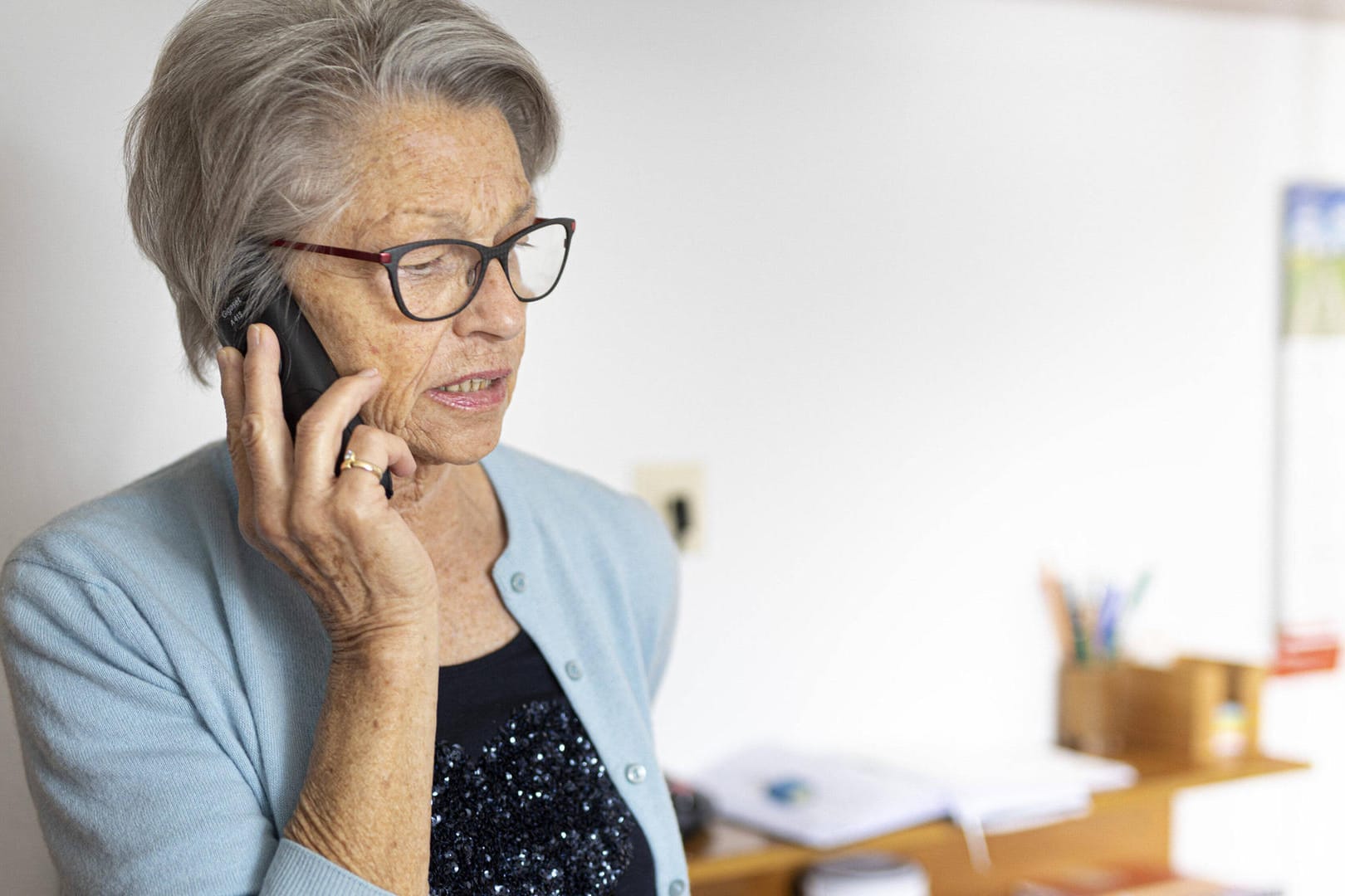 Frau mit einem Festnetztelefon: Gespräche ins Ausland können immer noch teuer sein.