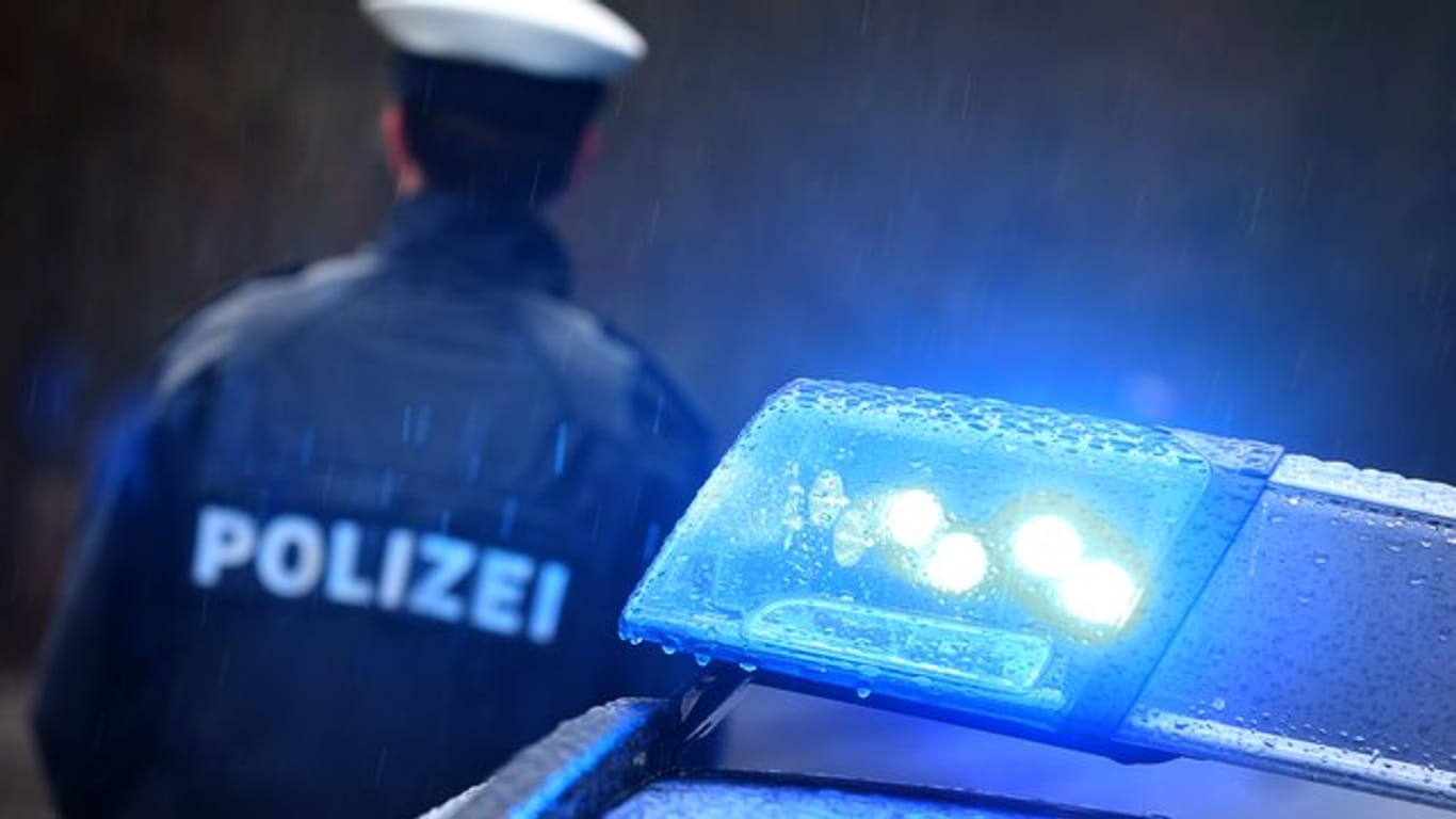 Ein Polizist steht vor einem Streifenwagen: In Hagen hat ein falscher Polizist erneut zugeschlagen.