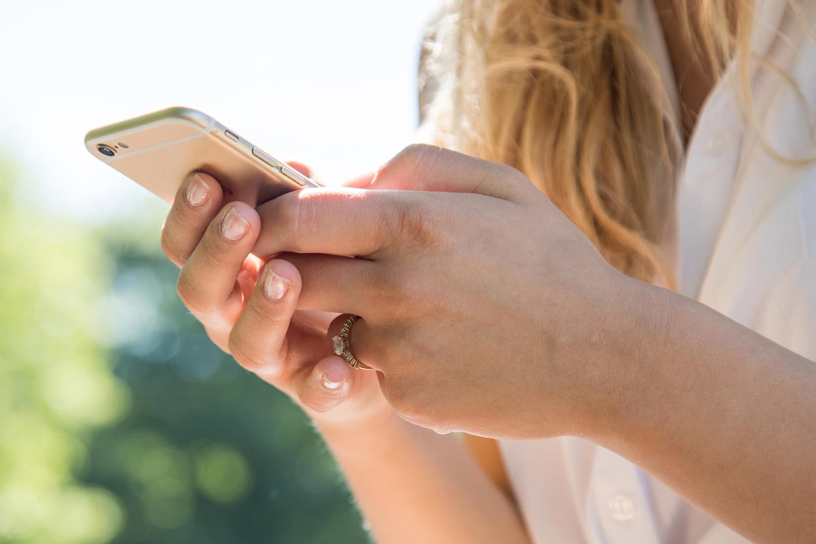 Eine Frau mit Smartphone: Wer bestehende Rabatte nicht aufs Spiel setzen will, sollte seinen Vertrag während der Laufzeit nicht ändern.
