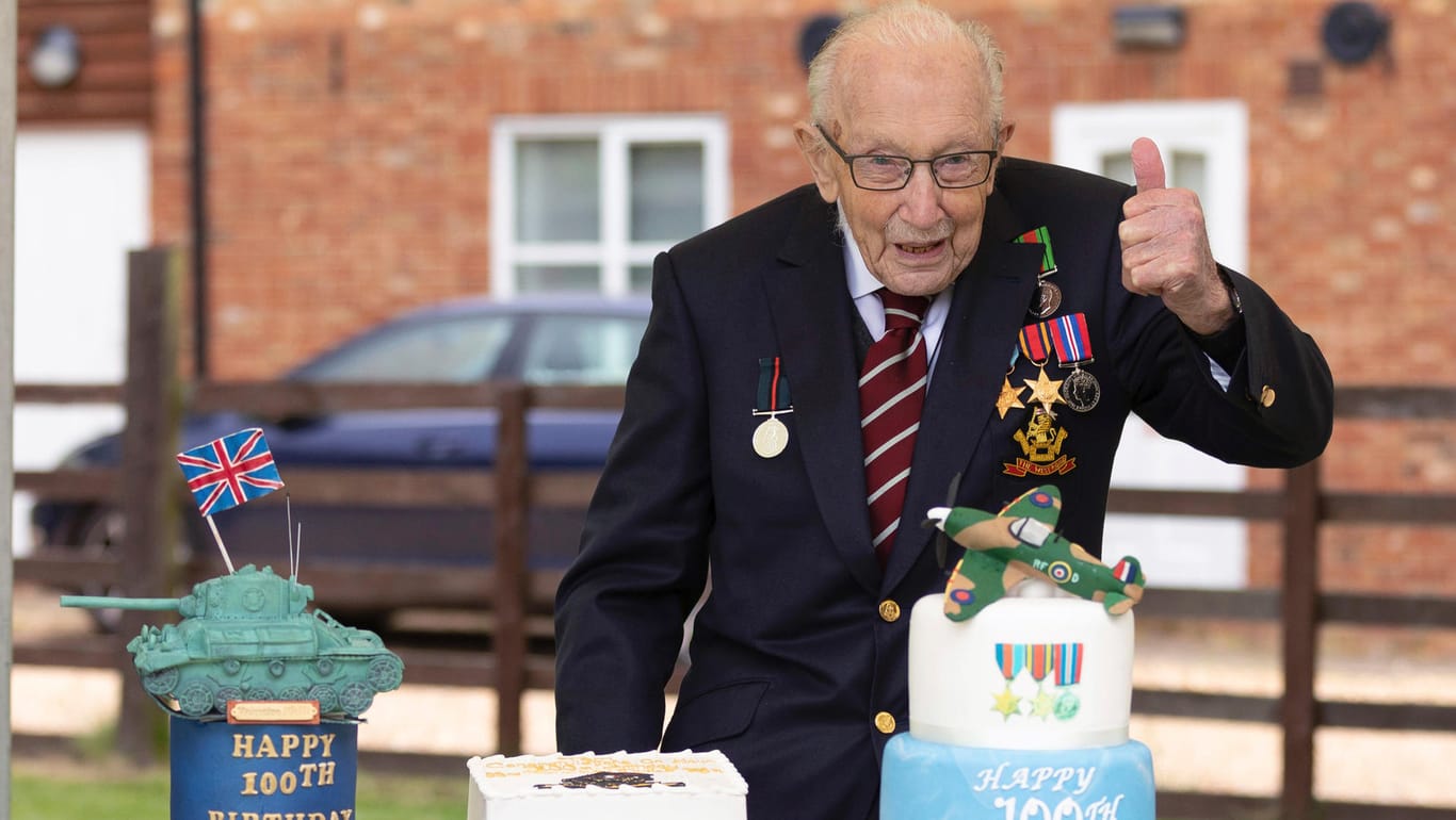 Tom Moore posiert mit einer Geburtstagstorte an seinem 100. Geburtstag.