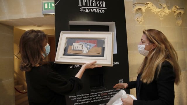 Die Organisatoren der Tombola, Peri Cochin (l) und Arabenne Reille, und Pablo Picassos Stillleben "Nature Mort".