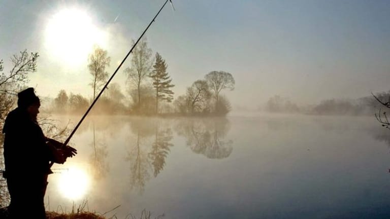 Ein Angler an einem Baggersee in Bayern.