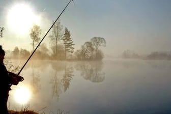 Ein Angler an einem Baggersee in Bayern.