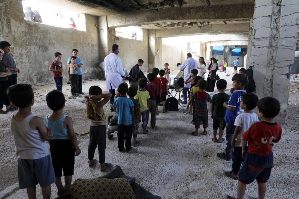 Zum Fest des Fastenbrechens lassen sich Kinder in einer Ruine in der syrischen Enklave Idlib die Köpfe scheren.