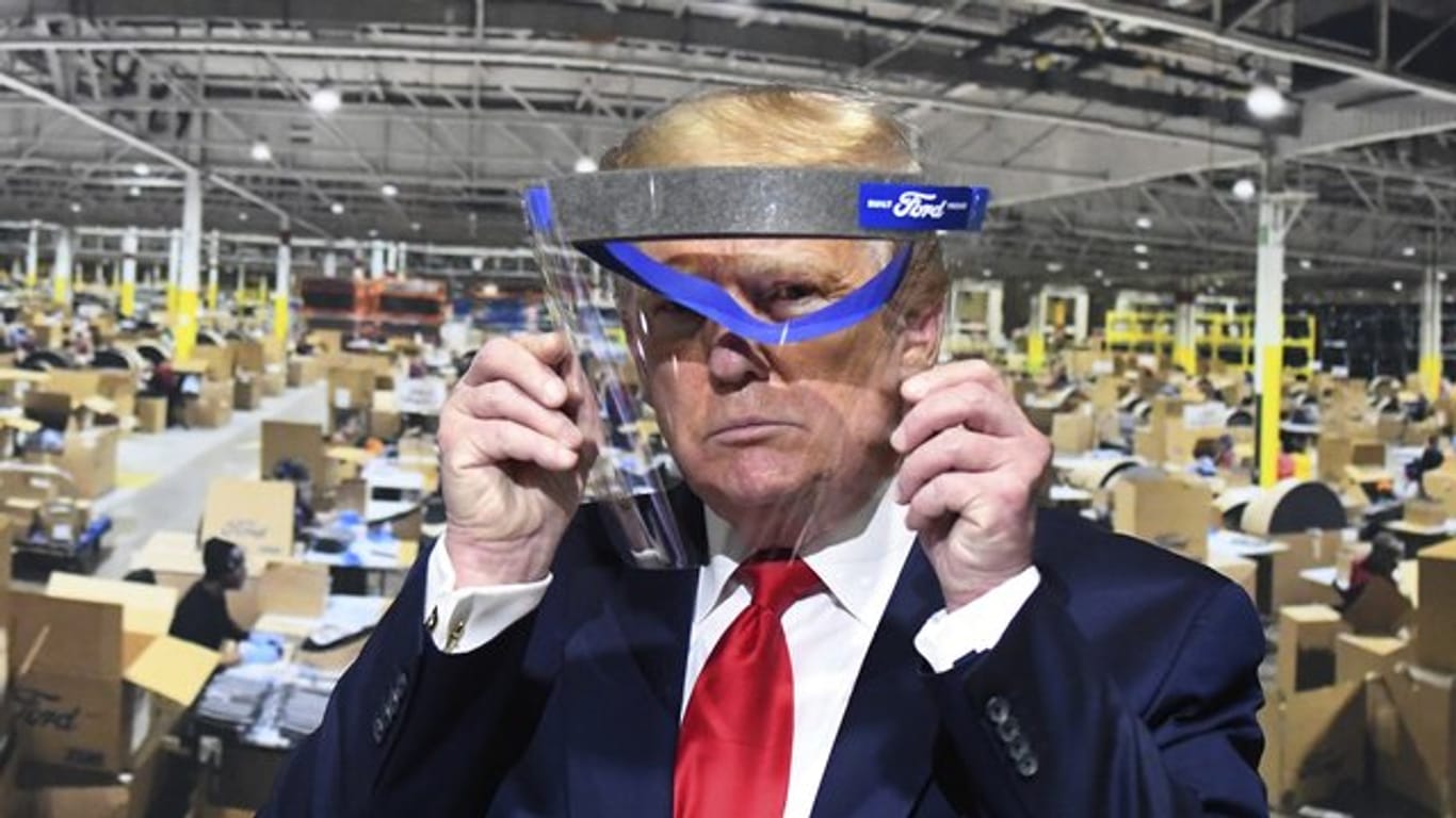 Donald Trump hält während des Rundgangs in einem Ford-Werk ein Gesichtsvisier in den Händen - einen Mundschutz trug er trotz Aufforderung nicht.
