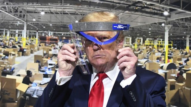 Donald Trump hält während des Rundgangs in einem Ford-Werk ein Gesichtsvisier in den Händen - einen Mundschutz trug er trotz Aufforderung nicht. Donald Trump hält während des Rundgangs in einem Ford-Werk ein Gesichtsvisier in den Händen - einen Mundschutz trug er trotz Aufforderung nicht.