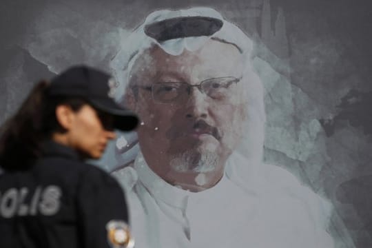 Eine Polizistin geht in der Nähe des saudischen Konsulats in Istanbul an einem Wandbild des ermordeten Journalisten Jamal Khashoggi vorbei.