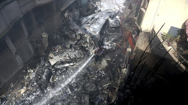 Ein Feuerwehrmann versucht, das Feuer an der Absturzstelle zu löschen. Ein Feuerwehrmann versucht, das Feuer an der Absturzstelle zu löschen.