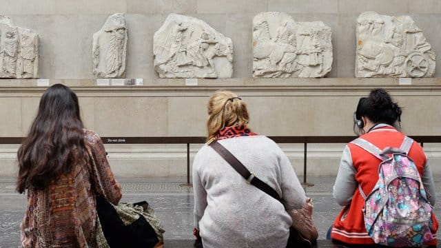 Besucher des British Museum in London sitzen vor Parthenon-Friesteilen. Besucher des British Museum in London sitzen vor Parthenon-Friesteilen.