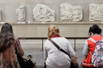 Besucher des British Museum in London sitzen vor Parthenon-Friesteilen.