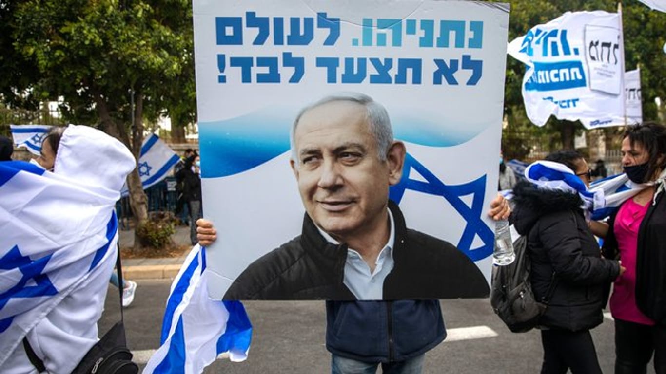 Anhänger von Ministerpräsident Netanjahu schwenken Fahnen und halten Plakate vor seiner Residenz in Jerusalem hoch.