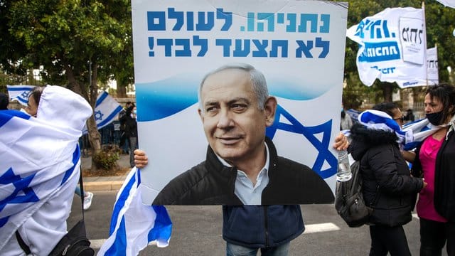 Anhänger von Ministerpräsident Netanjahu schwenken Fahnen und halten Plakate vor seiner Residenz in Jerusalem hoch. Anhänger von Ministerpräsident Netanjahu schwenken Fahnen und halten Plakate vor seiner Residenz in Jerusalem hoch.