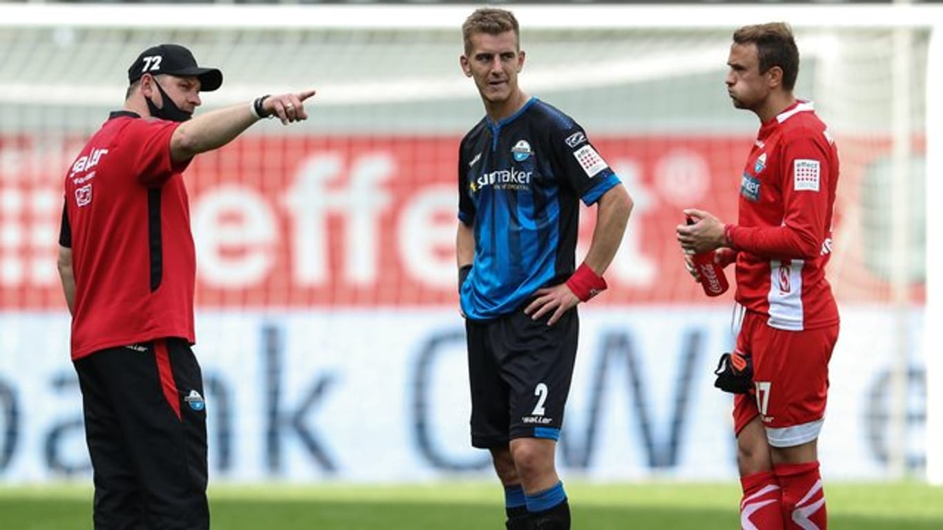 Paderborns Trainer Steffen Baumgart spricht nach dem Spiel mit Uwe Hünemeier und Torwart Leopold Zingerle (l-r).