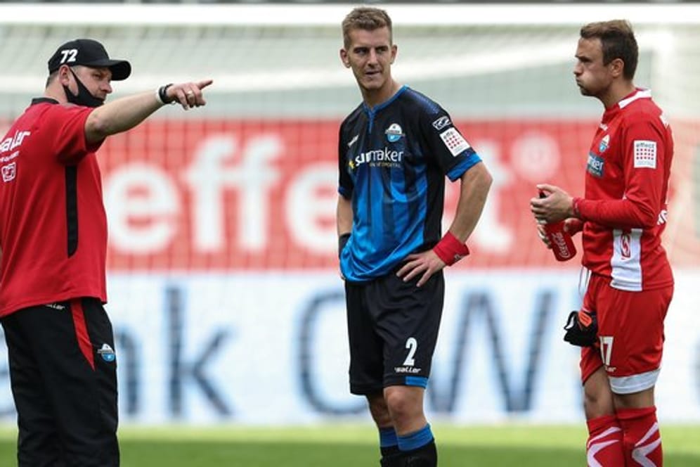 Paderborns Trainer Steffen Baumgart spricht nach dem Spiel mit Uwe Hünemeier und Torwart Leopold Zingerle (l-r).
